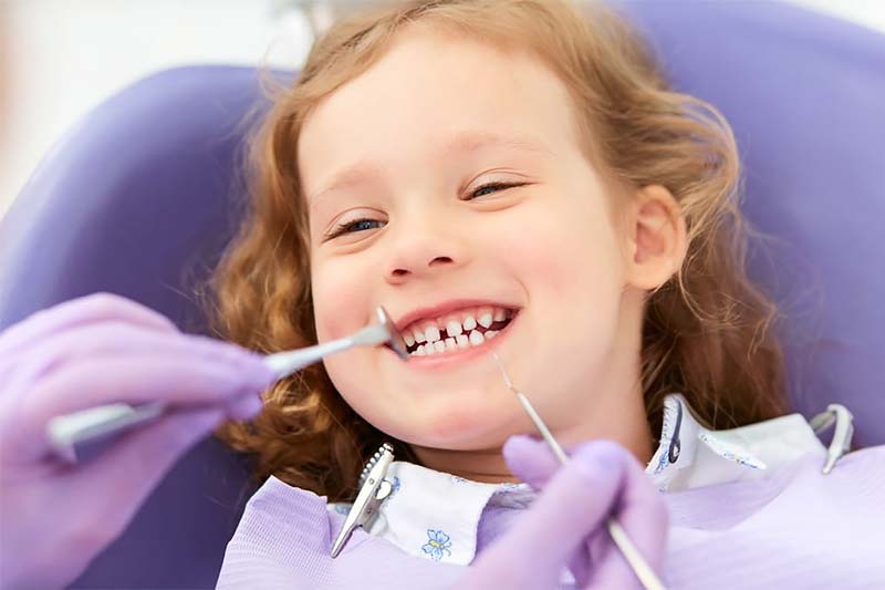 Niña sonriente en el dentista.