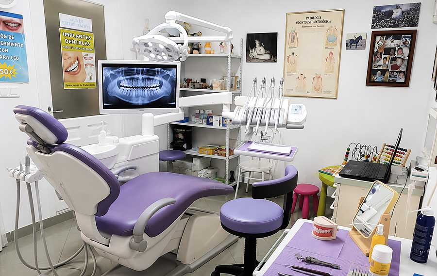 Gabinete dental moderno con sillón morado y equipo odontológico preparado para una primera consulta.